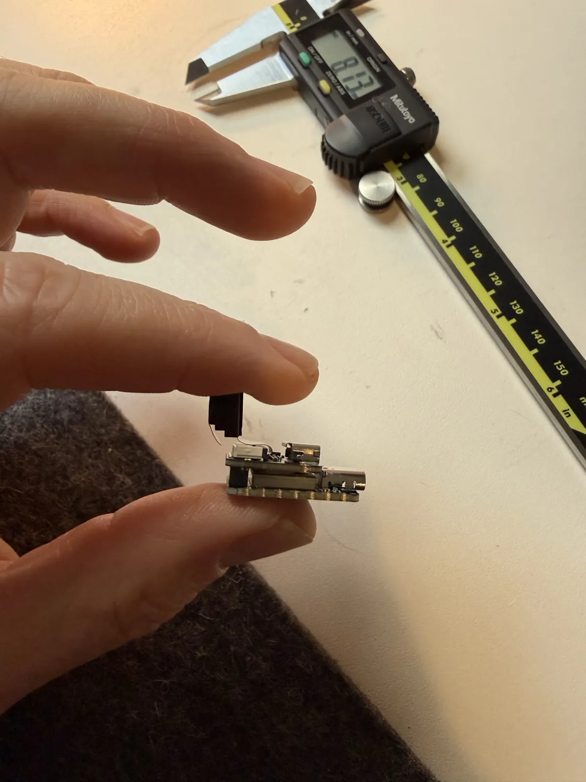 The XIAO board stack with its camera attached, being measured